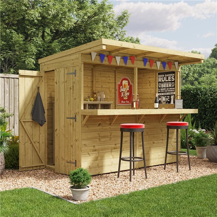 A Garden Bar Shed viewed from at a side angle decorated with bunting and two bar stools on a gravelled garden section.